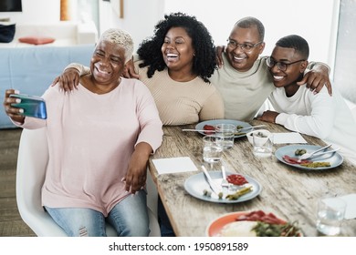 Happy Black Family Taking A Selfie With Mobile Phone At Home - Father, Daughter, Son And Mother Having Fun Together Sitting At Dinner Table - Main Focus On Boy Face