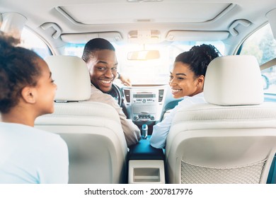 Happy Black Family Of Three Enjoying Car Ride During Summer Road Trip On Weekend. Cheerful Parents And Daughter Riding New Automobile. Cars Sales And Purchase Concept. Selective Focus, Back View