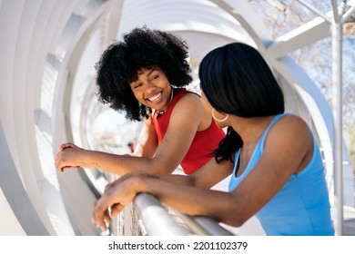 Happy Black Female Friends Talking And Laughing In The City. One Of Them Has Cool Afro Hair.