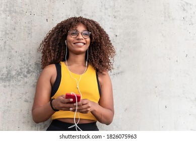 Happy Black Fit Woman Listening A Playlist On Her Mobile Phone After Running Session- Focus On Face