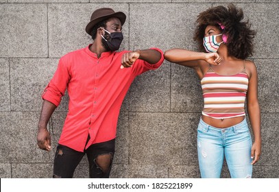 Happy Black Friends Wearing Protective Masks While Bumping Their Elbows Instead Of Greeting With A Hug - Focus On Faces