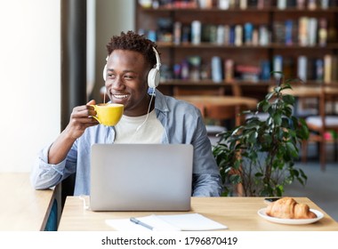 Happy Black Guy With Headphones Listening To Music And Drinking Aromatic Coffee At Cozy Cafe, Blank Space