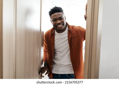 Happy Black Guy Opening Door Of His Apartment And Smiling Looking At Camera Standing Indoor. Welcome To My New Home. Real Estate Service And Property Purchase Concept