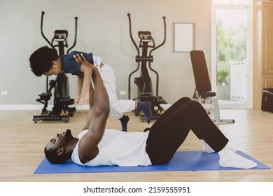 Happy Black Healthy Father Lying Enjoy Playing Lift Excited Little Child Son In Fitnees Sport Happiness Moment.