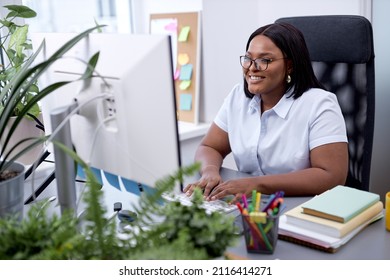 Happy black lady in formal wear sit working on pc computer in modern office, working online on project, startup. manager female concentrated on work, enjoy. business people, management