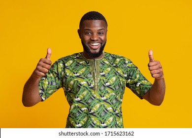 Happy Black Man In Green African Shirt Showing Thumbs Up Over Yellow