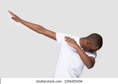 Happy black man making dab arms gesture on blank white grey studio background, funny african guy dabbing moving in internet meme pose celebrating victory having fun, dance school or triumph concept