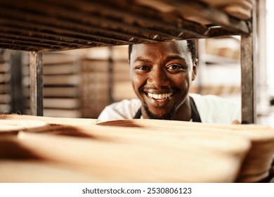 Happy black man, portrait or bakery with trolley for pastry production, bread or rolls at factory. Young African, male person or baker with smile for stock, inventory or handmade produce at warehouse - Powered by Shutterstock