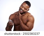 Happy black man, portrait and bottle with cologne for fresh smell, scent or hygiene on a white studio background. Young African, male person or model smile in antiperspirant, fragrance or after shave