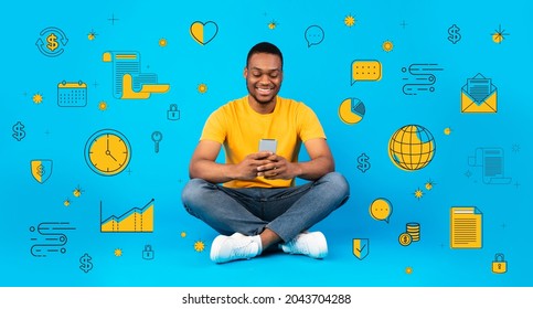 Happy Black Man Using Mobile Phone, Sitting Among Money, Finance And Business Icons On Blue Studio Background, Collage. Banner Design. Financial Literacy, Economy School Concept