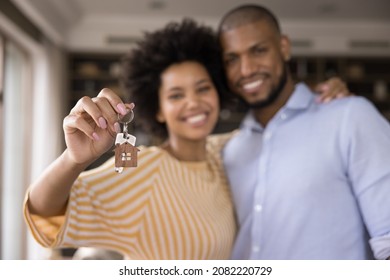 Happy Black millennial couple showing keys, smiling at camera, hugging. Husband and wife, new homeowners, tenants excited with house buying, real estate property purchase, renting apartment. Close up