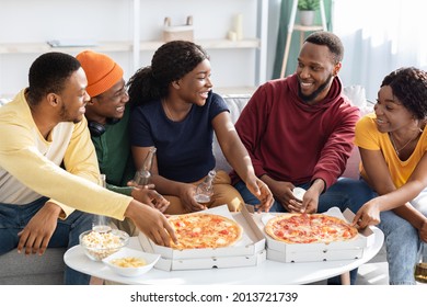 Happy Black Millennials Eating Pizza And Drinking Beer At Home, Sitting On Couch In Living Room, Having Conversation And Laughing, African American Friends Enjoying Time Together, Closeup