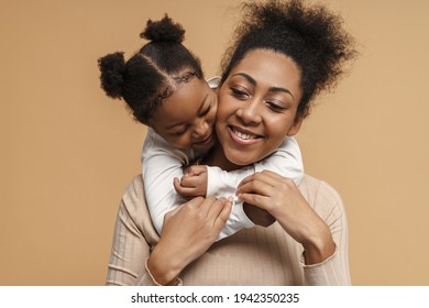 Happy Black Mother And Daughter Hugging While Making Fun Together Isolated Over Beige Background