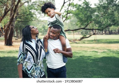 Happy Black People Family In Garden With Son Playing Airplane Toy