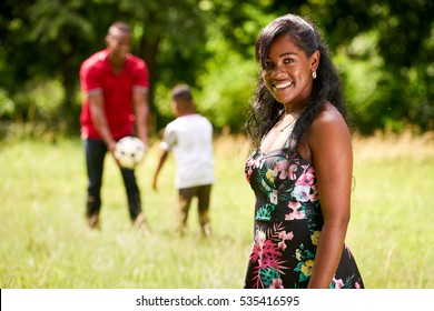 Happy Black People In Park. African American Family With Young Father And Son Having Fun With Football. Portrait Of Mother Smiling