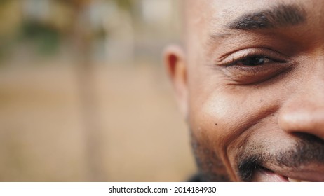 Happy Black Person Smiling. Close-up Of Young Half Face Of Handsome African American Man Looking Straight At Camera. Close Up Of Eye.