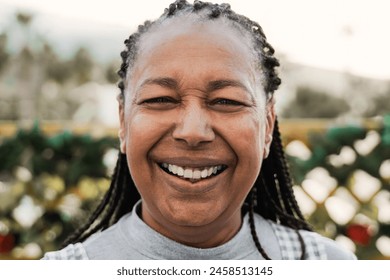 Happy black senior woman smiling looking at camera outdoors. Elderly people, diverse ethnic concept - Powered by Shutterstock