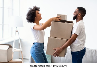 Happy Black Spouses Packing Boxes For Moving, Relocating To New Apartment Standing At Home. Real Estate Rent, Mortgage And Ownership Concept. Family Preparing To Move House.