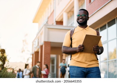 Happy Black University Student Standing At Campus And Looking Away, Copy Space.