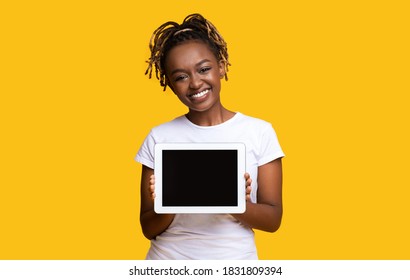 Happy Black Woman Holding Digital Tablet With Blank Screen Over Yellow Background. African American Young Lady Smiling And Holding Pad With Empty Screen, Copy Space For Text Or Advertisement