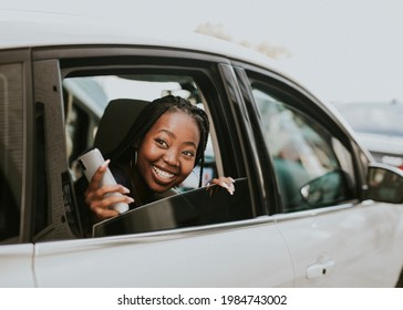 Happy black woman looking out of the car the window