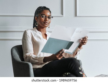 Happy Black Woman Reading A Unique Magazine