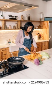 Happy Black Woman Using Cutting Vegetables In The Kitchen At Home And Smiling.