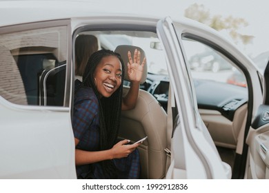 Happy Black Woman Waving Goodbye From A Car