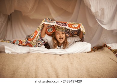 Happy, blanket fort and portrait of child relaxing and playing hide and seek with quilt at home. Excited, smile and face of girl kid with positive, good and playful expression in bedroom at house. - Powered by Shutterstock