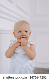 A Happy Blond Baby Girl With Blue Eye Against White Background