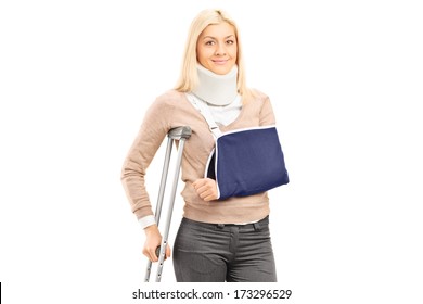 Happy Blond Female With Broken Arm Holding A Crutch Posing Isolated On White Background