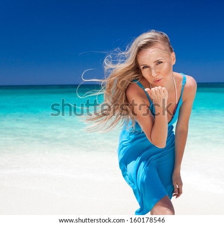 Young, slender, long-legged woman on a Baltic beach in a summer dress