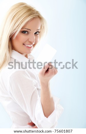 Happy blond woman showing blank credit card. Focus on card.