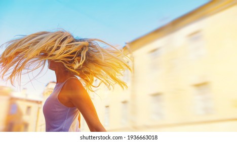 Happy blond woman in white t shirt enjoy her free time in warm summer city. Wind blow flying long light hair. Teen girl model sun shine glow. fresh air relax, new day, tan lady power, life joy concept - Powered by Shutterstock