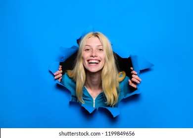 Happy Blonde Girl Looking Through Hole In Paper. Woman Breaking Through Paper Wall. Emotions. Emotional Woman Breaking Through Paper. Season Sales. Discount, Sale. Black Friday Shopping. Advertising.