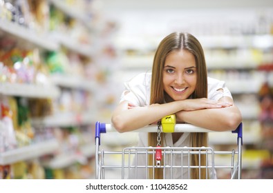 Happy blonde shopper smiles over supermarket shopping cart - Powered by Shutterstock