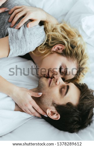 Similar – Young couple in love embracing lying over a bed