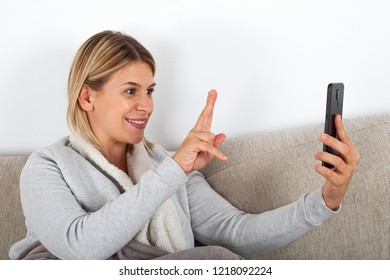 Happy Blonde Woman Talking On Facetime Showing Her Fingers To Friend