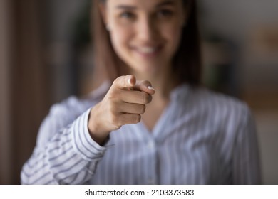 Happy blurred young woman pointing index finger at camera, smiling. Businesswoman, employer, HR manager choosing you. We need you, human resource, hiring, employment concept. Close up of hand