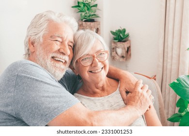 Happy bonding loving middle aged senior retired couple sitting on sofa looking in distance, recollecting good memories or planning common future, enjoying peaceful moment together at home. - Powered by Shutterstock