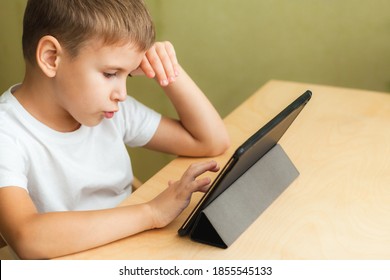 Happy boy doing homework with laptop at home. Child using gadgets for study. Education and distance learning concept - Shutterstock ID 1855545133