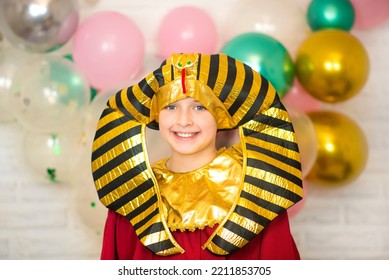 Happy Boy Dressed As A Pharaoh Stands In Front Of A Brick Wall Decorated With Balloons