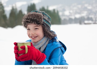 Happy Boy Drinking Hot Chocolate In Snowy Field