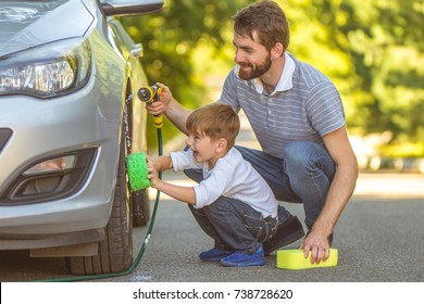 The Happy Boy And A Father Washing A Car