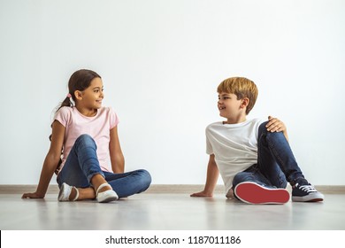 The Happy Boy And A Girl Sitting On The Floor