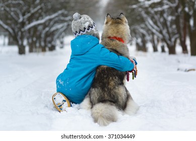 happy boy hugging dog or husky outdoors in winter day - Powered by Shutterstock