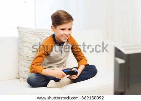 Similar – happy child playing video games with gamepad at home