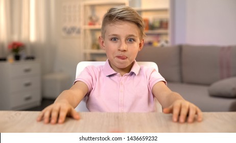 Happy Boy Licking Lips And Looking At Tasty Food On Kitchen Table, Nutrition