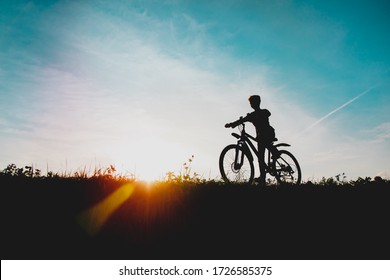 Happy Boy On Bike Ride In Sunset Nature