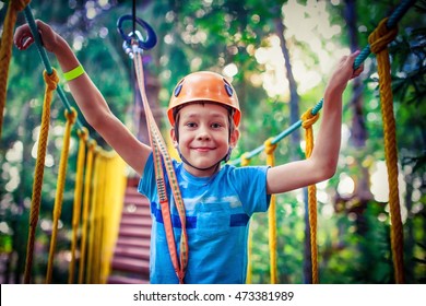 happy boy on the zip line. proud of his courage the child in the high wire park. HDR - Powered by Shutterstock